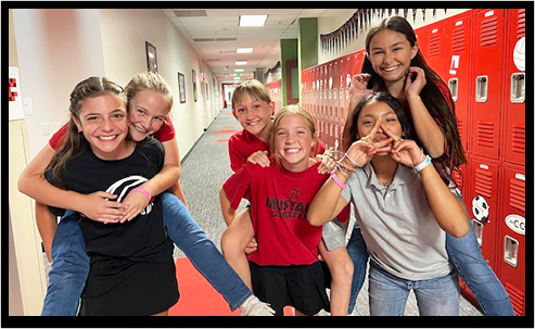 High school students sitting on stairs smiling